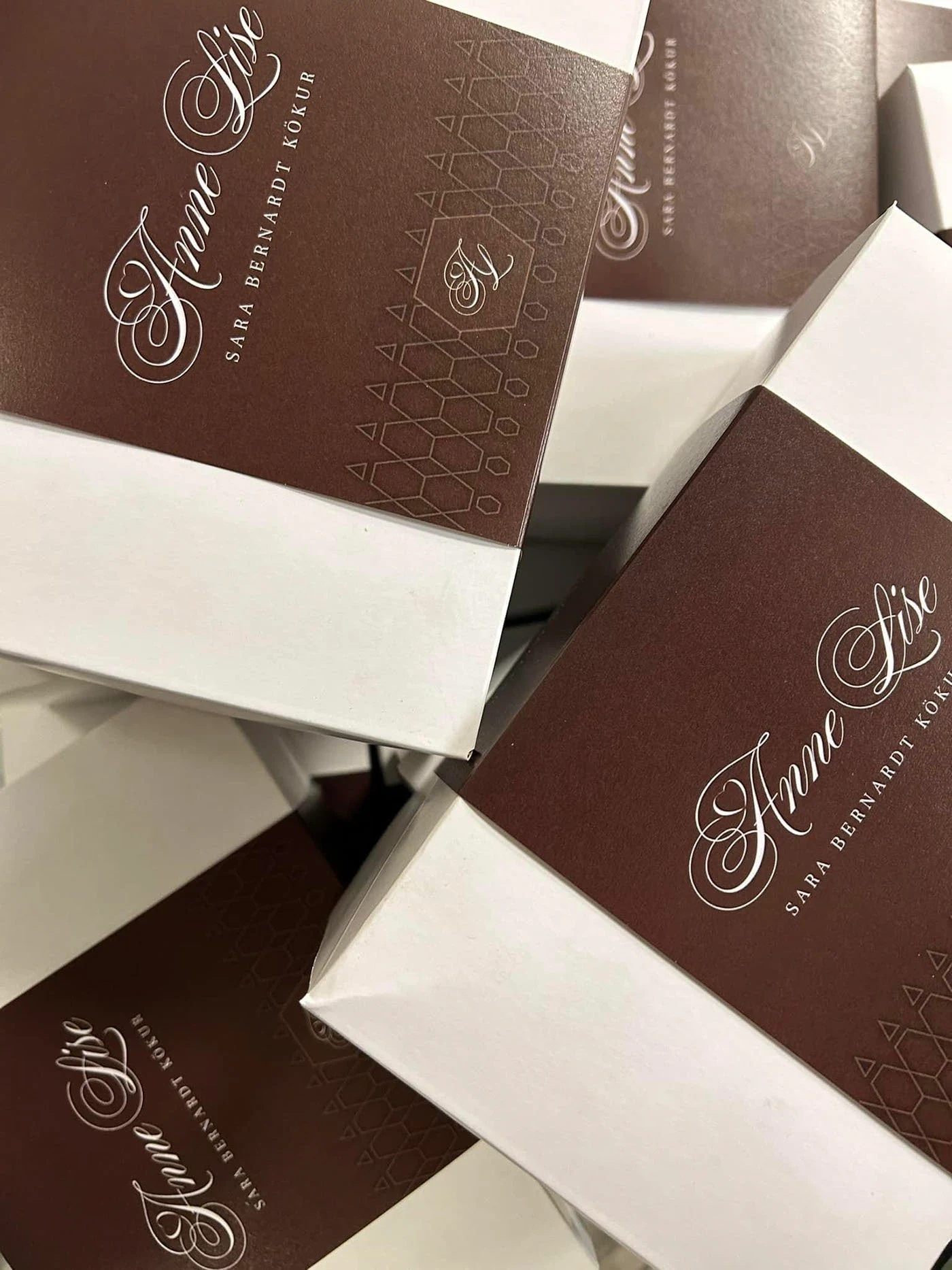 Chocolate boxes with flowing lettering and delicate gold patterns.
