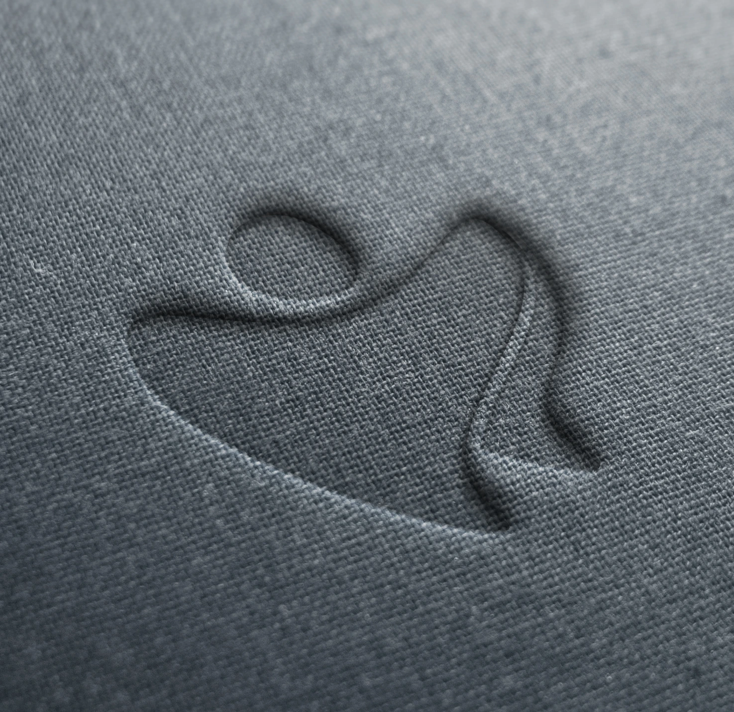 Symbol embossed into a textured surface.